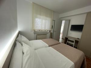 a bedroom with a bed with white sheets and a window at Appartamento 31 H in Taormina