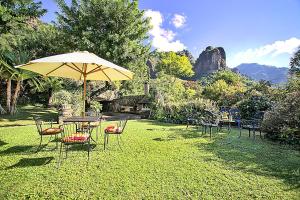 a group of tables and chairs with an umbrella at Casa Jacobina Tepoztlán in Tepoztlán