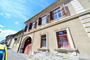 a building with windows and a door on a street at Anna's Guest House in Sibiu