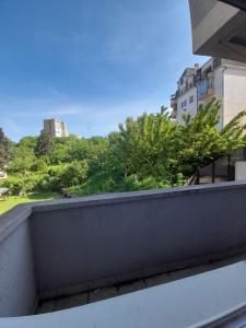 balcón con vistas a los árboles y edificios en Nirvana SPA Center, en Belgrado