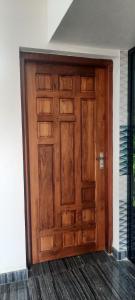 Cette chambre dispose d'une grande porte en bois. dans l'établissement Dalam Home at Irikkur, à Irikkūr
