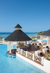 a hotel room with a pool and a beach at Secrets St. James in Montego Bay