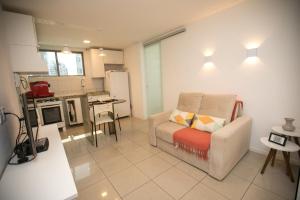 a living room with a couch and a kitchen at Flat Quarto e Sala, 400 metros da Praia de Boa Viagem, com Piscina, Wi-Fi 220Mbps in Recife
