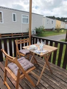 een houten tafel en twee stoelen op een terras bij Slow M'Ocean Villa in Pataias