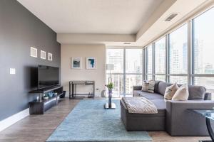 een woonkamer met een bank en een tv bij Luxury 1BR Condo - King Bed - Stunning City View in Toronto
