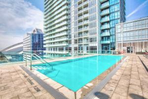 een groot zwembad voor een hoog gebouw bij Luxury 1BR Condo - King Bed - Stunning City View in Toronto