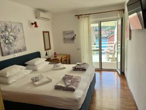 a bedroom with a large bed with towels on it at Guest house Šuda in Lumbarda