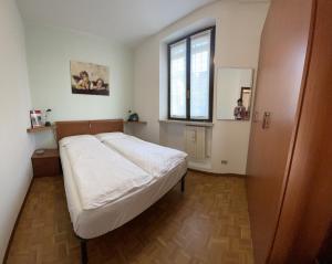 a bedroom with a white bed and a window at Appartamento alla Playa in Brenzone sul Garda