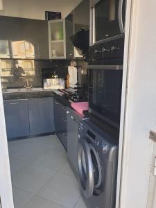 Una cocina con estufa, lavadora y secadora. en Garden Beach Sidi Rahal, en Sidi Rahal