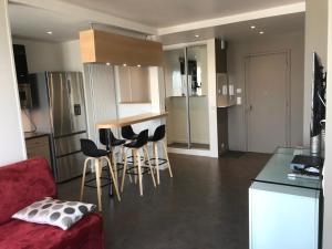 een keuken en een woonkamer met een rode bank en stoelen bij LuxAppart-Paris in Parijs