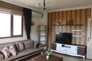 a living room with a couch and a television at Konaklar Apart Premium in Trabzon