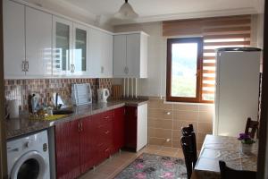 a kitchen with white cabinets and a table and a window at Konaklar Apart Premium in Trabzon