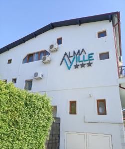 a white building with a sign on the side of it at AlmaVille Mamaia in Mamaia Nord