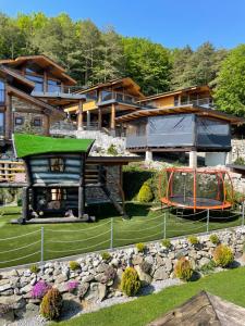 uma casa com um telhado verde e um parque infantil em Mountain Chalets Valča em Valca