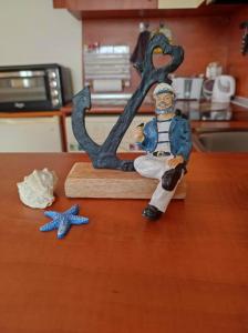 une figurine assise sur un comptoir à côté d'une lettre m dans l'établissement Студио Слънчево утро, à Bourgas 4 autres photos