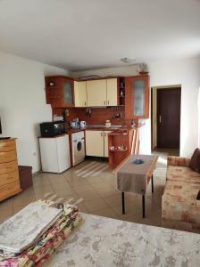 un salon avec une table et une cuisine dans l'établissement Студио Слънчево утро, à Bourgas