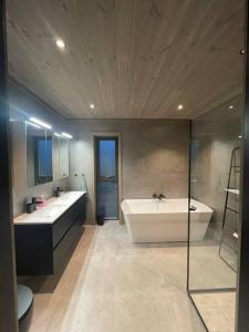 La salle de bains est pourvue de 2 lavabos, d'une baignoire et de toilettes. dans l'établissement Resvegen 63, à Stranda