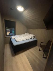 Habitación pequeña con cama y silla. en Resvegen 63, en Stranda