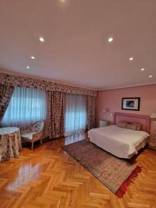 1 dormitorio con 1 cama grande y suelo de madera en La Casona Imperial, en Alpedrete