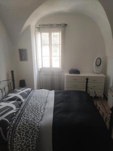 a bedroom with a black and white bed and a window at San Martino b&b in Toirano