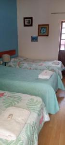 a group of three beds in a room at Hostal don Felipe in Guadalajara