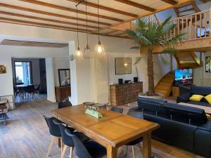 uma sala de estar com uma mesa de madeira e uma sala de estar em Bienvenue à la Villa Plagnal Classée 3 étoiles em Aubière