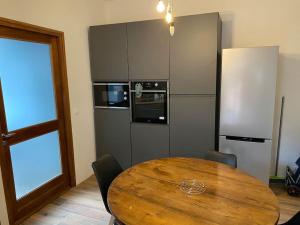 eine Küche mit einem Holztisch und einem Kühlschrank in der Unterkunft Bienvenue à la Villa Plagnal Classée 3 étoiles in Aubière