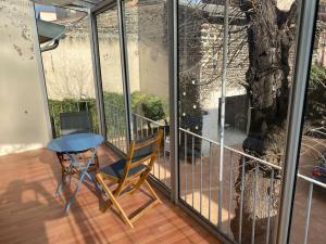 d'un balcon avec une chaise, une table et un arbre. dans l'établissement Bienvenue à la Villa Plagnal Classée 3 étoiles, à Aubière