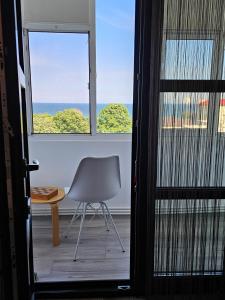 a chair sitting in a room with a window at La țărm in Mangalia