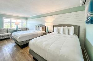 a hotel room with two beds and a chair at Thunderbird Beach Resort in St. Pete Beach