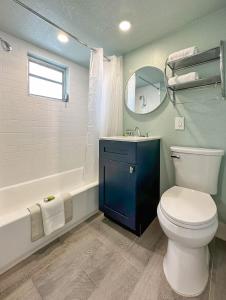 a bathroom with a toilet and a sink and a mirror at Thunderbird Beach Resort in St. Pete Beach