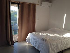 - une chambre avec un lit et une fenêtre avec un balcon dans l'établissement Posada El Mariscal, à Paso de los Toros
