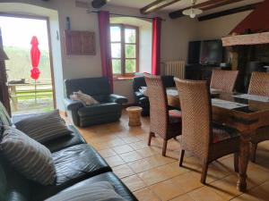 a living room with a couch and a table and chairs at Se reconnecter à la nature au gîte 3 étoiles de Montager à Saint André de Chalencon in Saint-André-de-Chalençon