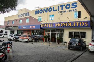 a hotel with cars parked in a parking lot at Hotel Monólitos in Quixadá
