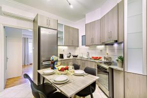 una cucina con tavolo, sedie e frigorifero di Ionian Citizen Suite a Città di Corfù