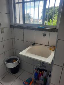 uma casa de banho com um lavatório e uma janela em Apartamento por temporada em Fortaleza