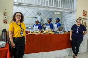 a group of women standing in front of a table with food at Hotel Monólitos in Quixadá