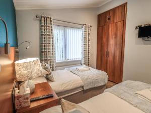 - une petite chambre avec 2 lits et une fenêtre dans l'établissement Cottontail Lodge, à Windermere