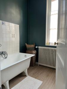 un bagno con vasca e finestra di ‘L’ éditeur’ - Maison de Maître Honfleuraise. a La Rivière Saint Sauveur