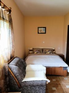 a bedroom with a bed and a couch in it at Apartment Perović in Nikšić