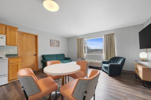 a kitchen and a living room with a table and chairs at Garibaldi Inn at the Bay in Garibaldi