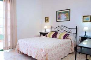 a bedroom with a bed and two tables with lamps at LIVE GUANCHES DE CANDELARIA in Candelaria