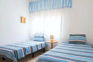 two beds in a room with a window at LIVE GUANCHES DE CANDELARIA in Candelaria