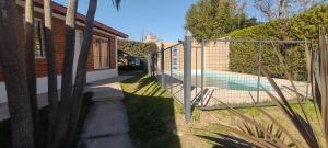 una valla junto a una casa con piscina en Cabañas La Gringa en Potrero de los Funes