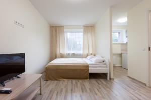 a small bedroom with a bed and a tv at Bright Apartment near Bus Statioon in Tallinn