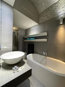 a bathroom with a large white tub and a sink at Portici Design Suite - Historical Center in Bologna