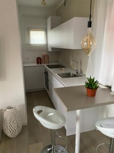 een witte keuken met een wastafel en een aanrecht bij Boutiqueloft Vista in Bardolino