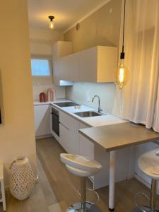 a kitchen with white cabinets and a sink and a table at Boutiqueloft Vista in Bardolino
