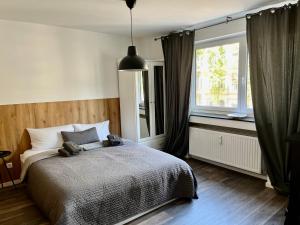 sypialnia z dużym łóżkiem i oknem w obiekcie Apartments KR w Kolonii
