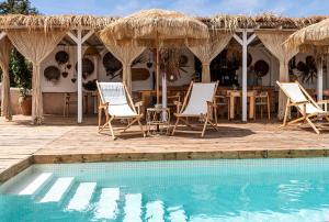 a group of chairs and a table and a swimming pool at Can Aisha - Adults Only in Es Pujols